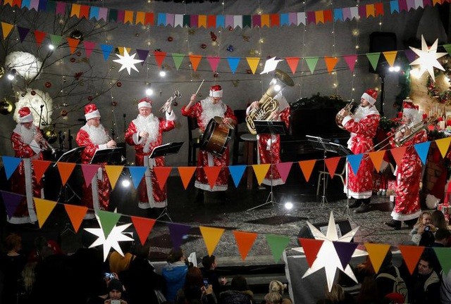 Các nhạc sĩ mặc quần áo ông già Noel biểu diễn ở Hội chợ Năm mới tại Nhà thờ St. Anne's Lutheran, Saint Petersburg, Nga ngày 22/12.