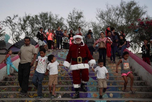 Bill Myers mặc trang phục ông già Noel chơi đùa cùng những đứa trẻ và dành tặng các em những món quà nhỏ trong một trại tị nạn ở Matamoros, Mexico
